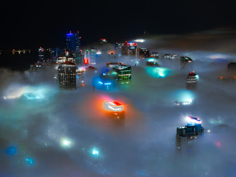 Miami skyline rising through the fog at night, aerial | Matthew Hoyos