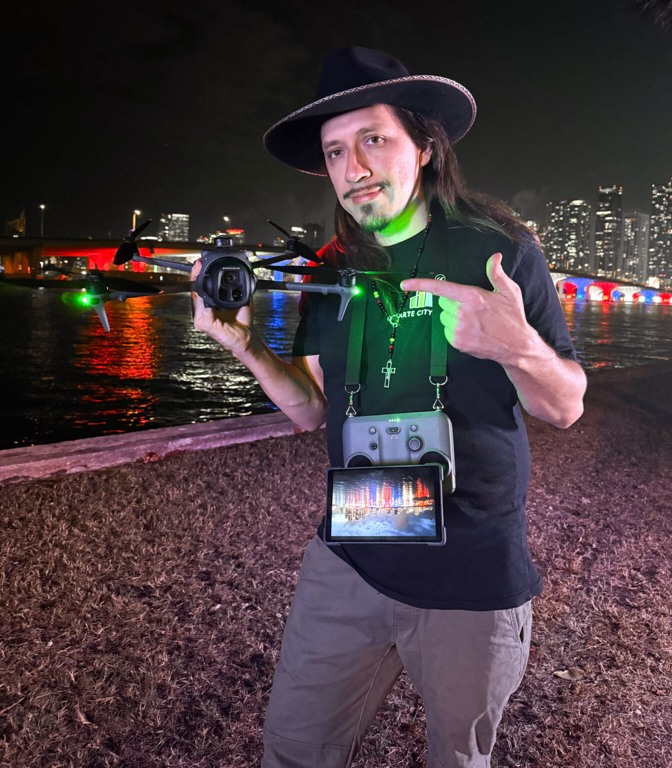 Matthew Hoyos holding a drone and controller on the beach at night in Miami