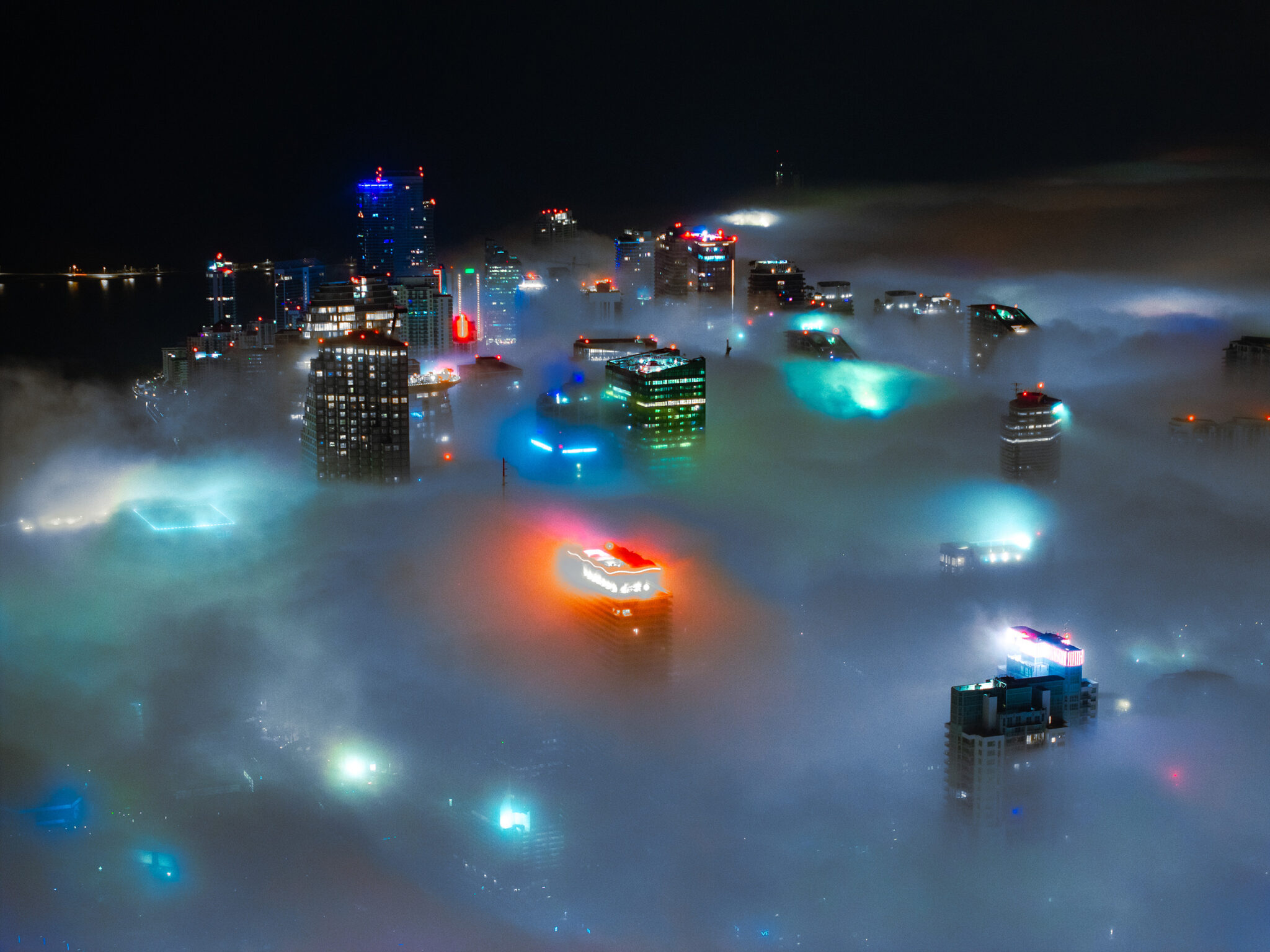 Miami skyline rising above a blanket of fog at night